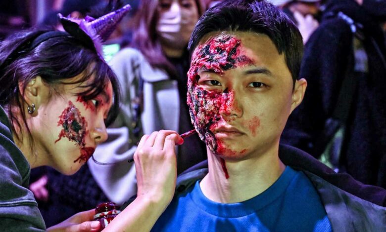 Nachtschwärmer schminken sich während der Halloween-Feierlichkeiten im beliebten Ausgehviertel Itaewon in Seoul am 28. Oktober 2022. (Foto von Jung Yeon-je / AFP)