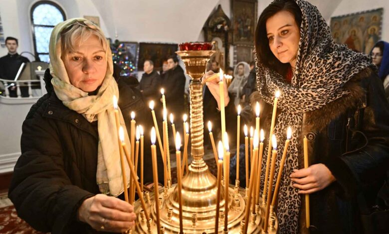 Frauen zünden während des Weihnachtsgottesdienstes in einer Kirche der orthodoxen Kirche der Ukraine in Kiew am 25. Dezember 2022 inmitten der russischen Invasion in der Ukraine Kerzen an. Kirchenglocken und Kyivan-Gesänge läuteten in der gesamten ukrainischen Hauptstadt, als orthodoxe Christen am 25. Dezember 2022 an den Weihnachtsgottesdiensten teilnahmen, einer trotzigen Pause von russischen geistlichen Führern, die den Feiertag in zwei Wochen markieren werden. Die Entscheidung einiger ukrainischer Kirchen, Weihnachten am 25. Dezember und nicht am 7. Januar zu feiern, wie es im orthodoxen Christentum üblich ist, unterstreicht die Kluft zwischen den religiösen Führern in Kiew und Moskau, die sich durch den anhaltenden Krieg vertieft hat. (Foto von Genya SAVILOV / AFP)
